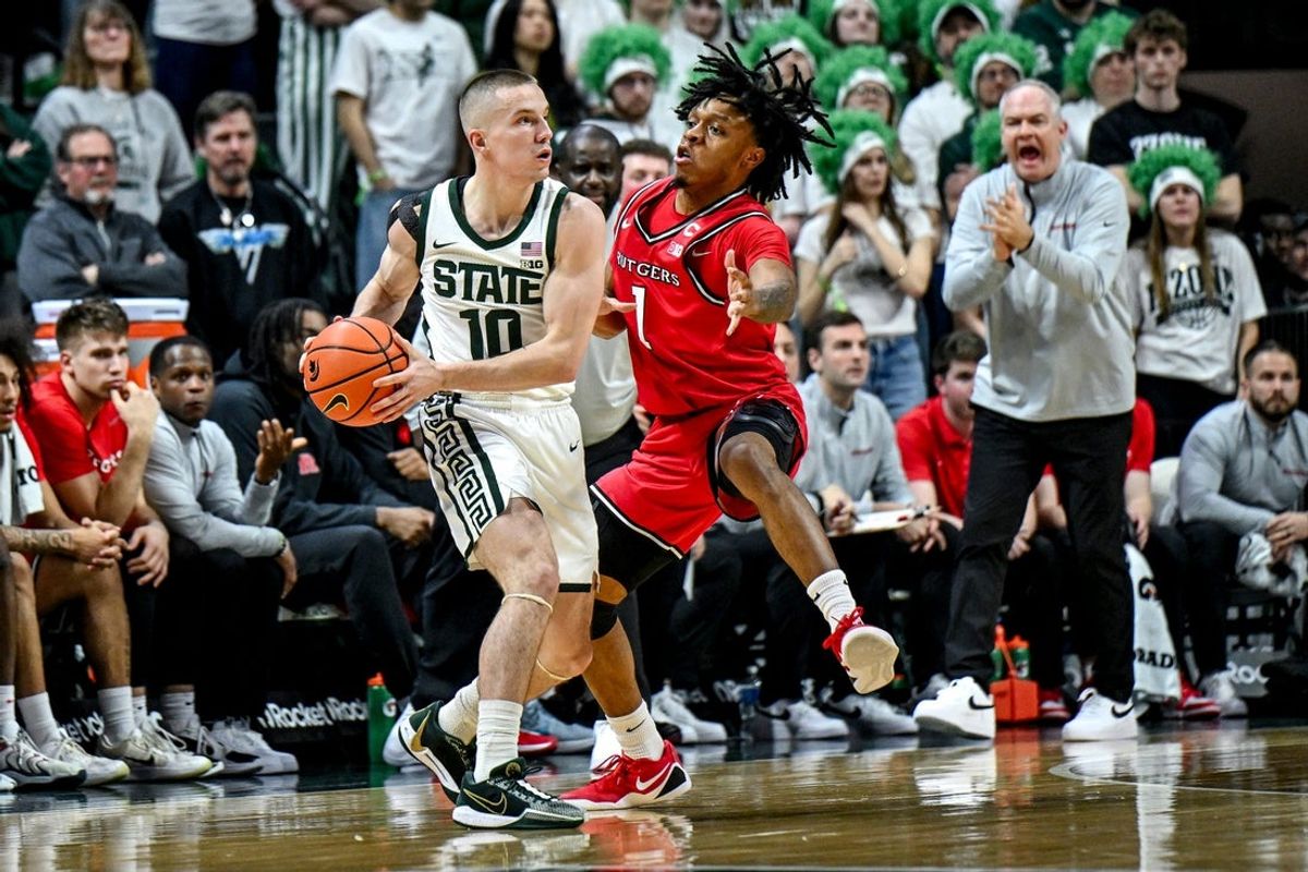 Michigan State's Denham Wojcik, left, looks to pass as Rutgers' Jamichael Davis defends during the first half on Thursday, March 5, 2026, at the Breslin Center in East Lansing.