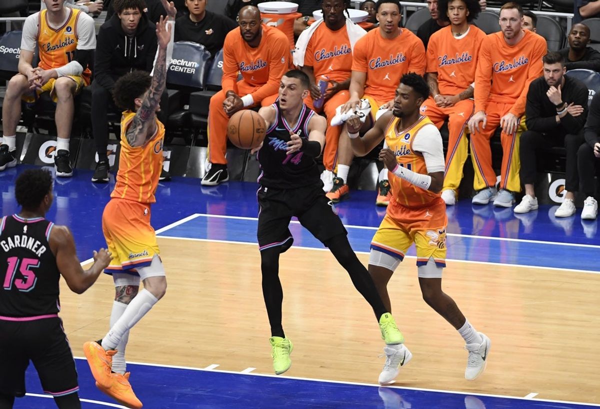 Mar 6, 2026; Charlotte, North Carolina, USA;  Miami Heat guard Tyler Herro (14) passes through the defense of Charlotte Hornets guard LaMelo Ball (1) and guard Brandon Miller (24) during the second half at the Spectrum Center. Mandatory Credit: Sam Sharpe-Imagn Images.