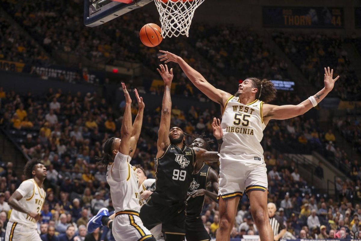 Mar 6, 2026; Morgantown, West Virginia, USA; West Virginia Mountaineers center Harlan Obioha (55) blocks a shot from UCF Knights forward Jordan Burks (99) during the first half at Hope Coliseum. Mandatory Credit: Ben Queen-Imagn Images