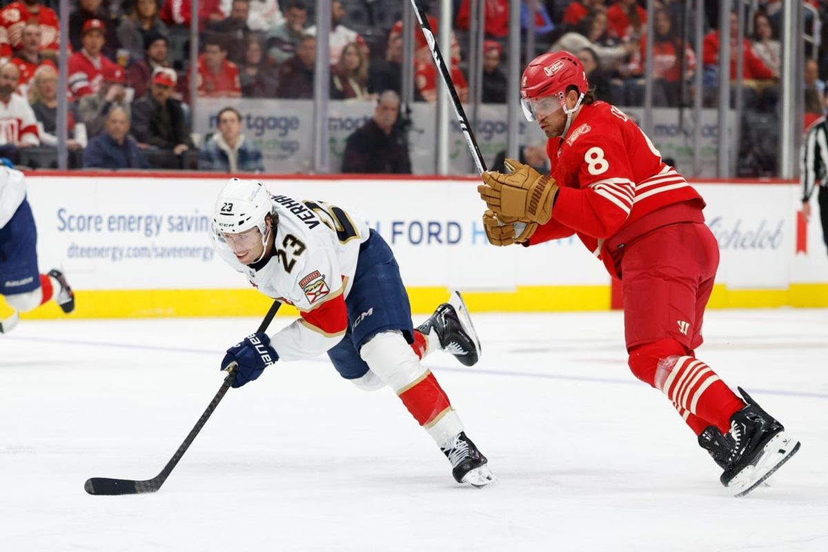 Mar 6, 2026; Detroit, Michigan, USA;  Florida Panthers center Carter Verhaeghe (23) skates with the puck defended by Detroit Red Wings defenseman Ben Chiarot (8) in the third period at Little Caesars Arena. Mandatory Credit: Rick Osentoski-Imagn Images
