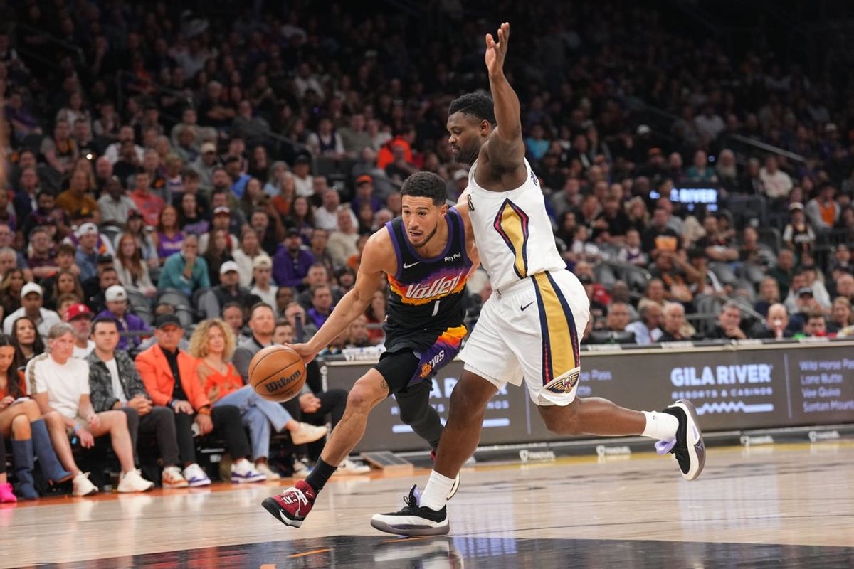 Mar 6, 2026; Phoenix, Arizona, USA; Phoenix Suns guard Devin Booker (1) drives against New Orleans Pelicans forward Zion Williamson (1) during the first half at Mortgage Matchup Center. Mandatory Credit: Joe Camporeale-Imagn Images