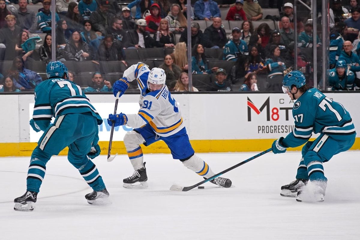 Mar 6, 2026; San Jose, California, USA; San Jose Sharks center Michael Misa (77) blocks a shot by St. Louis Blues left winger Dylan Holloway (81) as San Jose Sharks center Macklin Celebrini (71) helps defend in the first period at SAP Center at San Jose. Mandatory Credit: David Gonzales-Imagn Images