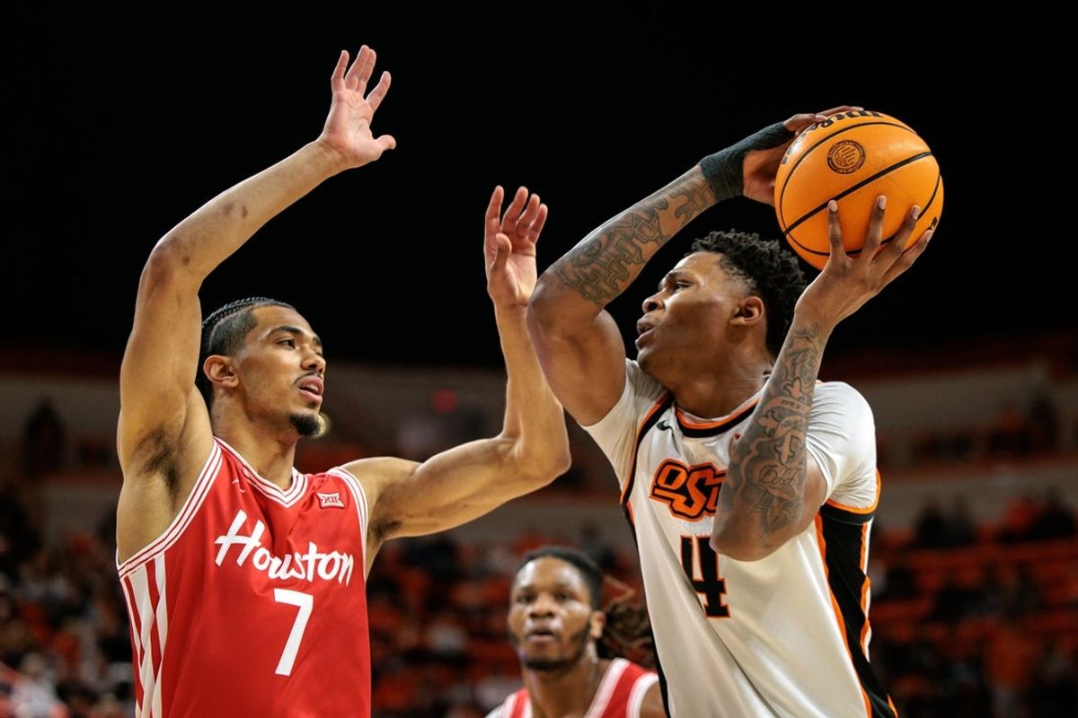 Mar 7, 2026; Stillwater, Oklahoma, USA;  Oklahoma State Cowboys guard Christian Coleman (4) drives around Houston Cougars guard Milos Uzan (7) during the first half at Gallagher-Iba Arena. Mandatory Credit: William Purnell-Imagn Images