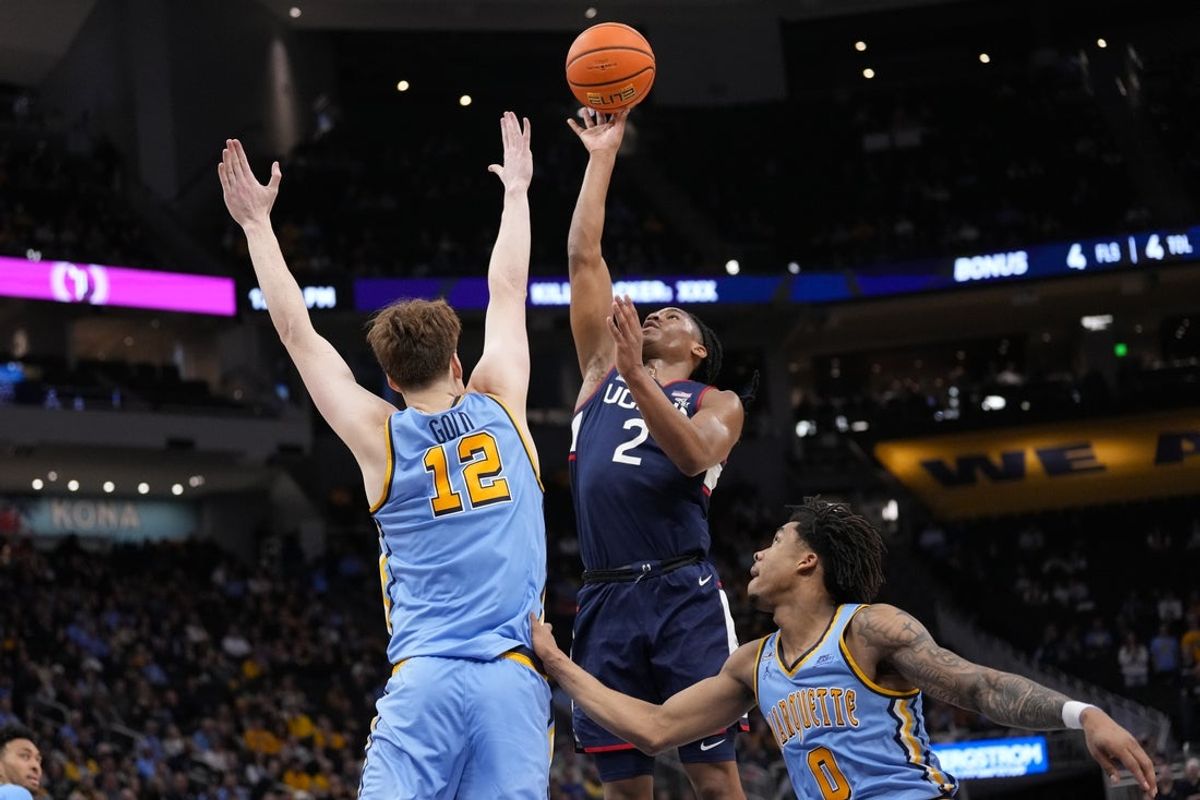 Mar 7, 2026; Milwaukee, Wisconsin, USA;  Connecticut Huskies guard Silas Demary Jr. (2) shoots against Marquette Golden Eagles forward Ben Gold (12) during the first half at Fiserv Forum. Mandatory Credit: Jeff Hanisch-Imagn Images