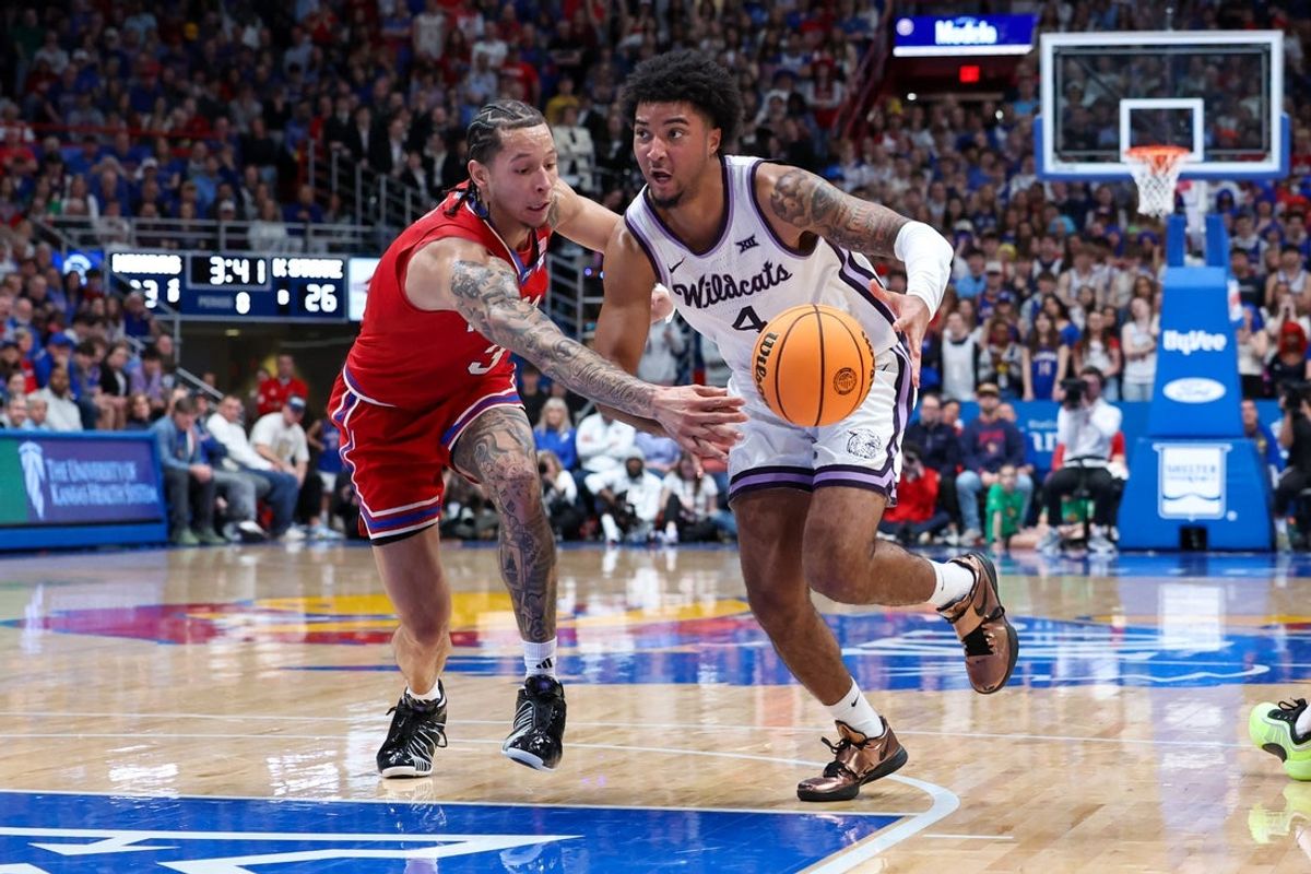 Mar 7, 2026; Lawrence, Kansas, USA; Kansas State Wildcats guard P.J. Haggerty (4) dribbles by Kansas Jayhawks guard Tre White (3) during the first half at Allen Fieldhouse. Mandatory Credit: Scott Sewell-Imagn Images