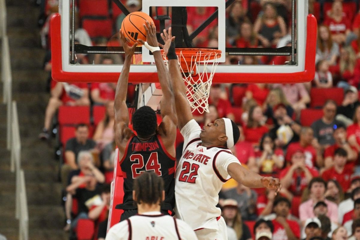 Mar 7, 2026; Raleigh, North Carolina, USA;  NC State Wolfpack forward Ven-Allen Lubin (22) contests Stanford Cardinal forward Jaylen Thompson (24) at the basket during the first half at Lenovo Center. Mandatory Credit: Zachary Taft-Imagn Images