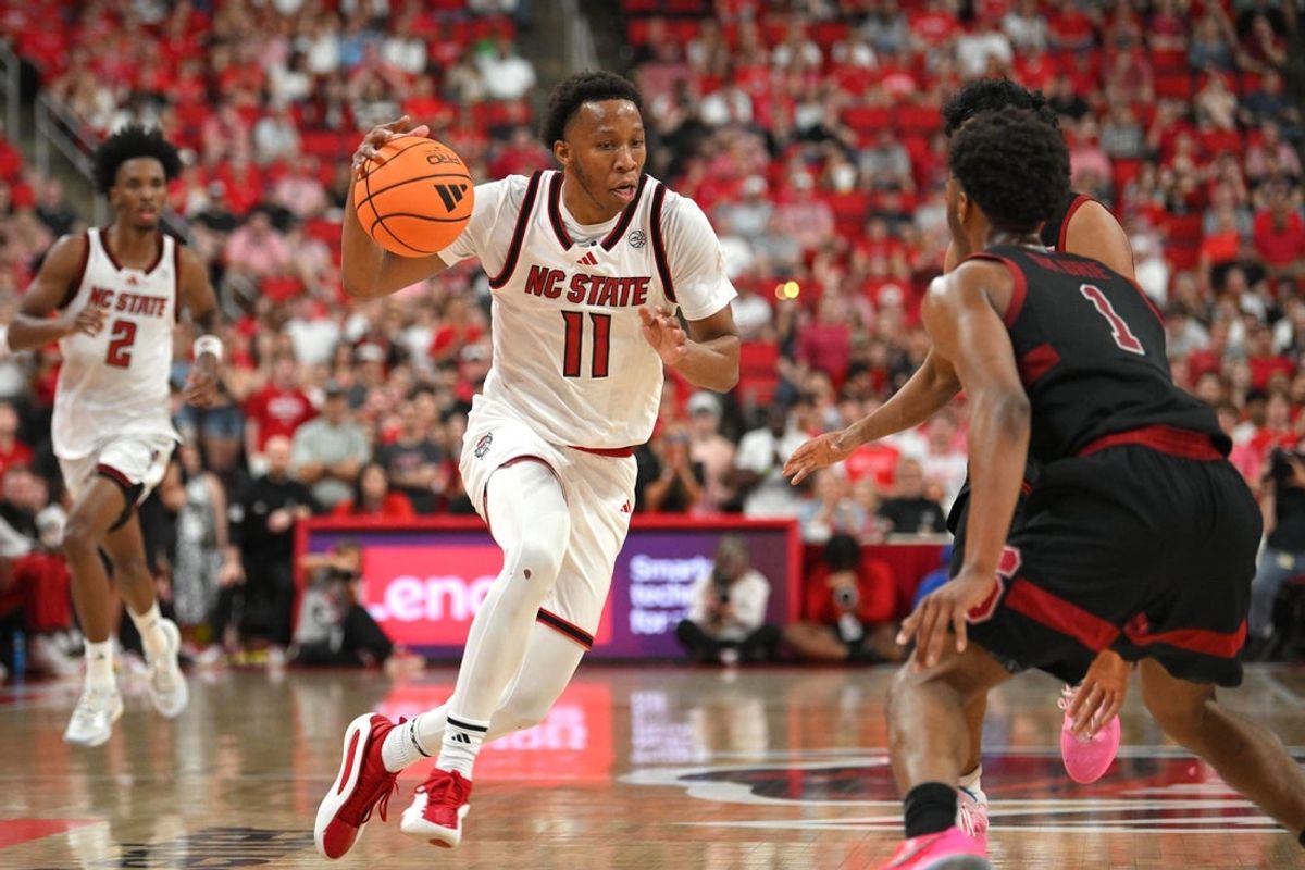 Mar 7, 2026; Raleigh, North Carolina, USA;  NC State Wolfpack guard Quadir Copeland (11) drives the ball against Stanford Cardinal guard Ebuka Okorie (1) during the first half at Lenovo Center. Mandatory Credit: Zachary Taft-Imagn Images