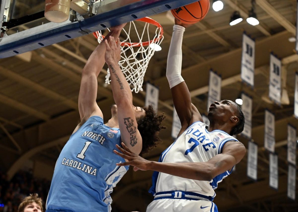 Mar 7, 2026; Durham, North Carolina, USA; North Carolina Tar Heels forward Zayden High (1) has his shot blocked by Duke Blue Devils forward Dame Sarr (7) during the first half at Cameron Indoor Stadium. Mandatory Credit: Rob Kinnan-Imagn Images