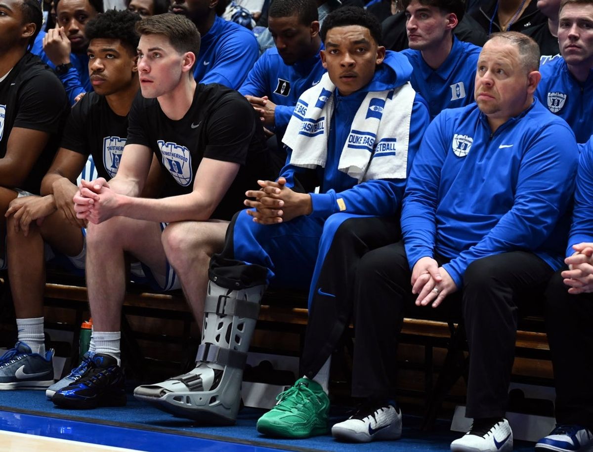 Mar 7, 2026; Durham, North Carolina, USA; Injured Duke Blue Devils  guard Caleb Foster (center) looks on with a while wearing a walking boot during the second half against the North Carolina Tar Heels at Cameron Indoor Stadium.  The Duke Blue Devils won 76-61. Mandatory Credit: Rob Kinnan-Imagn Images