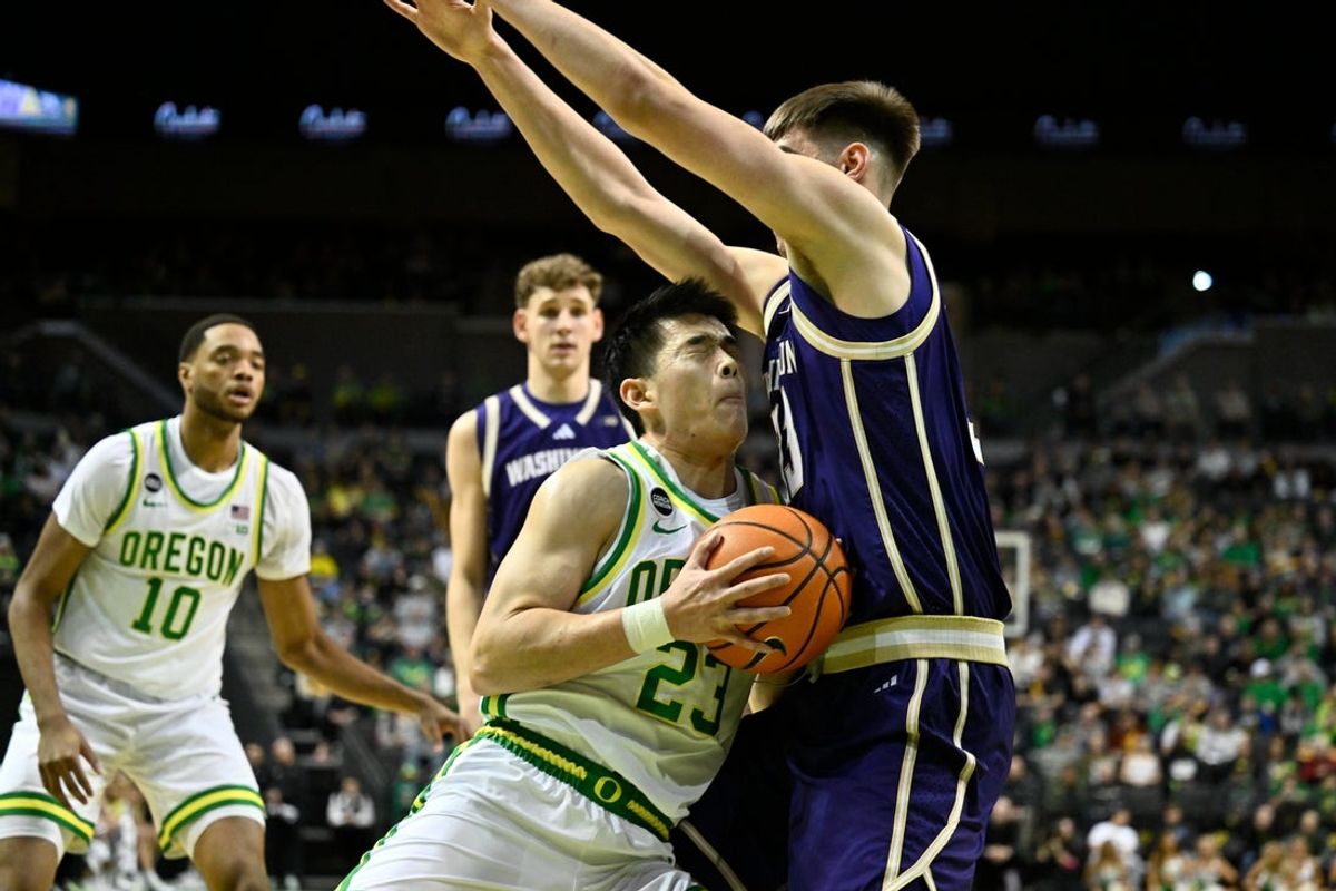 Mar 7, 2026; Eugene, Oregon, USA; Oregon Ducks guard Wei Lin (23) runs into Washington Huskies forward Nikola Dzepina (33) driving to the basket during the first half at Matthew Knight Arena. Mandatory Credit: Craig Strobeck-Imagn Images