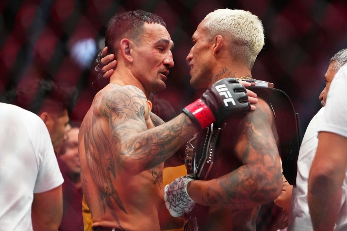 Mar 7, 2026; Las Vegas, Nevada, UNITED STATES; Max Holloway (red gloves) greets Charles Oliveira (blue gloves) after their fight during UFC 326 at T-Mobile Arena. Mandatory Credit: Stephen R. Sylvanie-Imagn Images