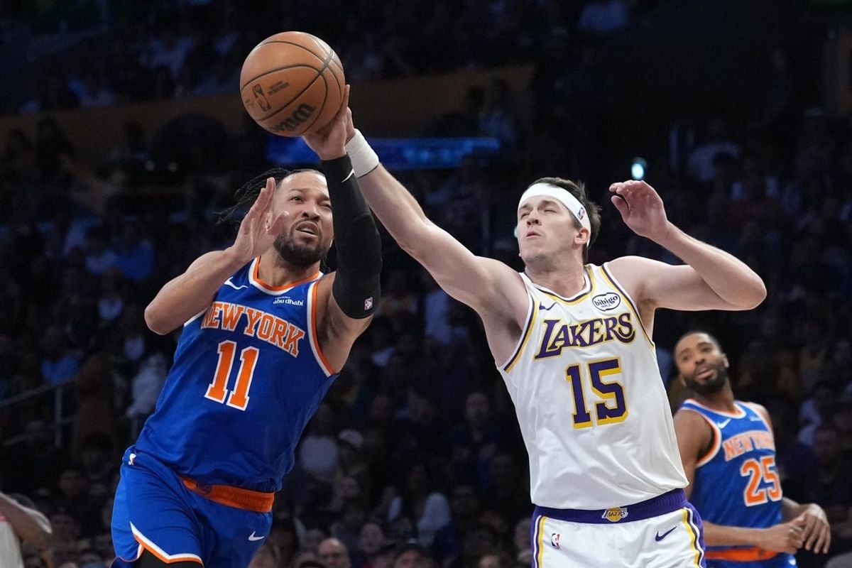 Mar 8, 2026; Los Angeles, California, USA; New York Knicks guard Jalen Brunson (11) and Los Angeles Lakers guard Austin Reaves (15) reach for the ball in the first half at Crypto.com Arena. Mandatory Credit: Kirby Lee-Imagn Images