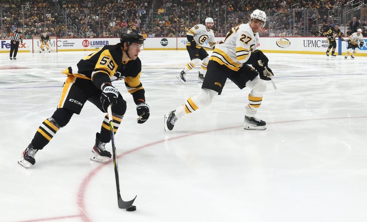 Mar 8, 2026; Pittsburgh, Pennsylvania, USA;  Pittsburgh Penguins right wing Egor Chinakhov (59) moves the puck against Boston Bruins defenseman Hampus Lindholm (27) during the first period at PPG Paints Arena. Mandatory Credit: Charles LeClaire-Imagn Images