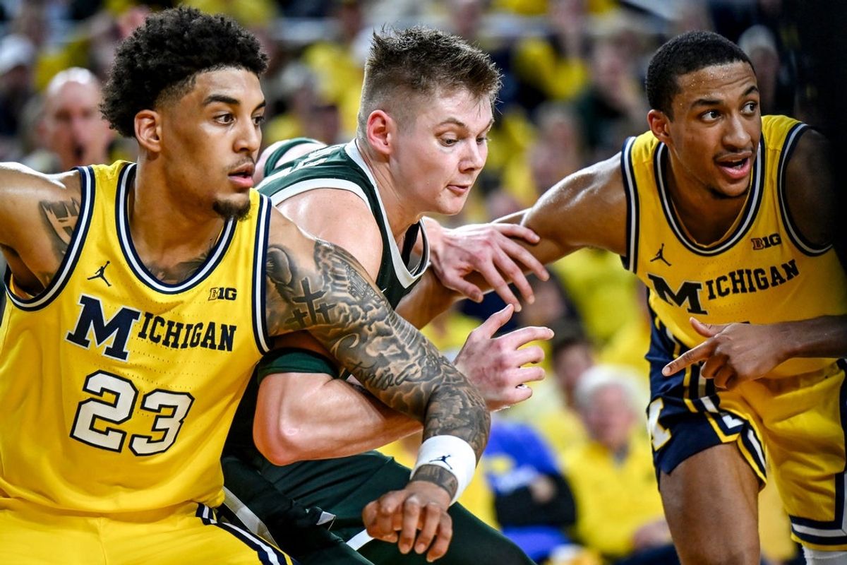 Michigan State's Jaxon Kohler, center, tries to get position on Michigan's Yaxel Lendeborg, left, and Nimari Burnett during the second half on Sunday, March 8, 2026, at the Crisler Center in Ann Arbor.