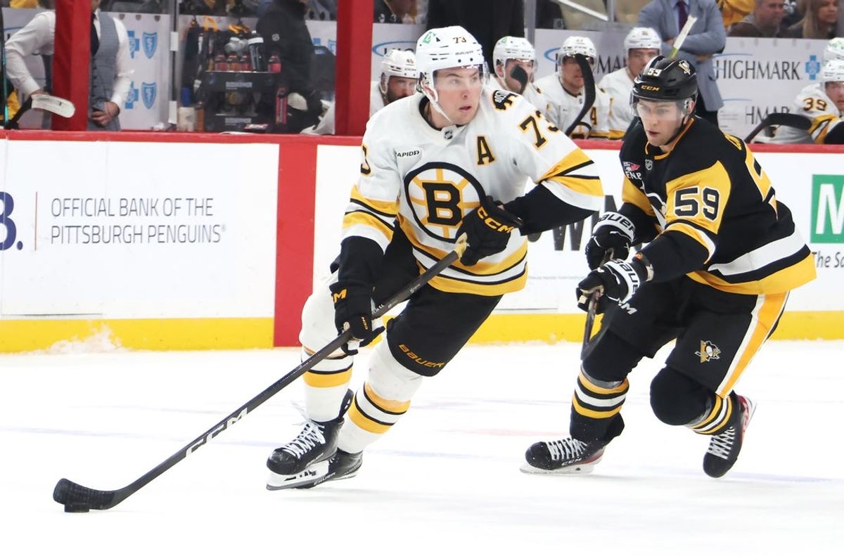 Mar 8, 2026; Pittsburgh, Pennsylvania, USA;  Boston Bruins defenseman Charlie McAvoy (73) handles the puck against Pittsburgh Penguins right wing Egor Chinakhov (59) in overtime at PPG Paints Arena. Mandatory Credit: Charles LeClaire-Imagn Images