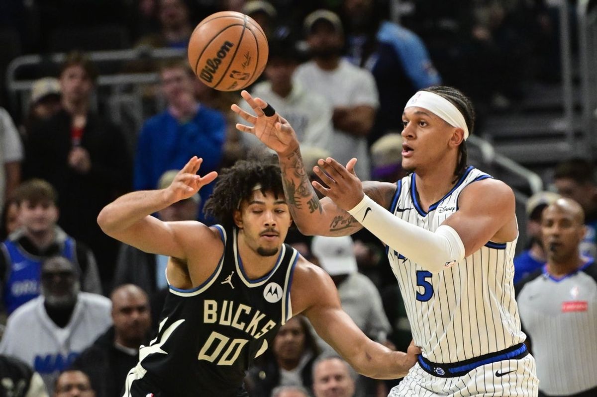 Mar 8, 2026; Milwaukee, Wisconsin, USA; Orlando Magic forward Paolo Banchero (5) passes the ball away from Milwaukee Bucks center Jericho Sims (00) in the first quarter at Fiserv Forum. Mandatory Credit: Benny Sieu-Imagn Images