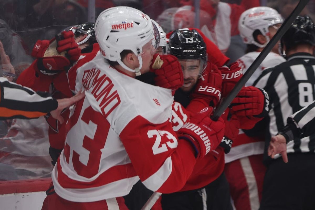Mar 8, 2026; Newark, New Jersey, USA;  Detroit Red Wings left wing Lucas Raymond (23) and New Jersey Devils center Nico Hischier (13) fight in the final seconds of the second period at Prudential Center. Mandatory Credit: Thomas Salus-Imagn Images