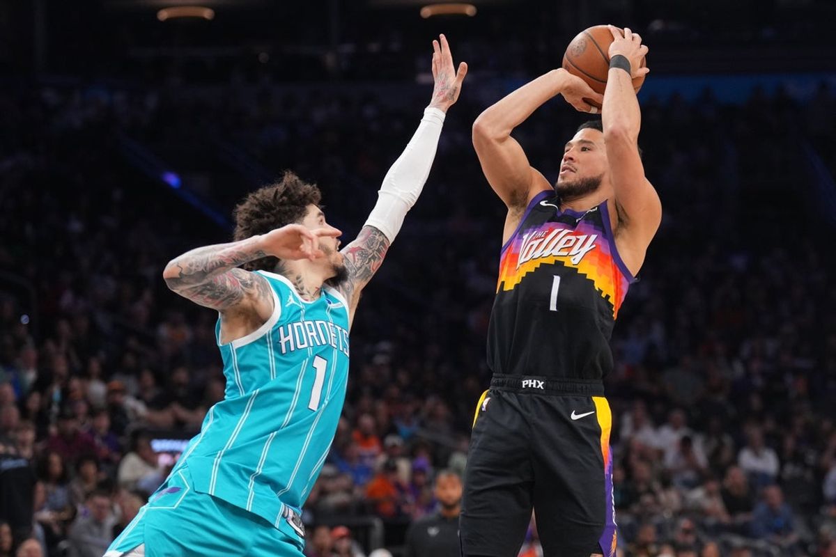 Mar 8, 2026; Phoenix, Arizona, USA; Phoenix Suns guard Devin Booker (1) shoots over Charlotte Hornets guard LaMelo Ball (1) during the second half at Mortgage Matchup Center. Mandatory Credit: Joe Camporeale-Imagn Images