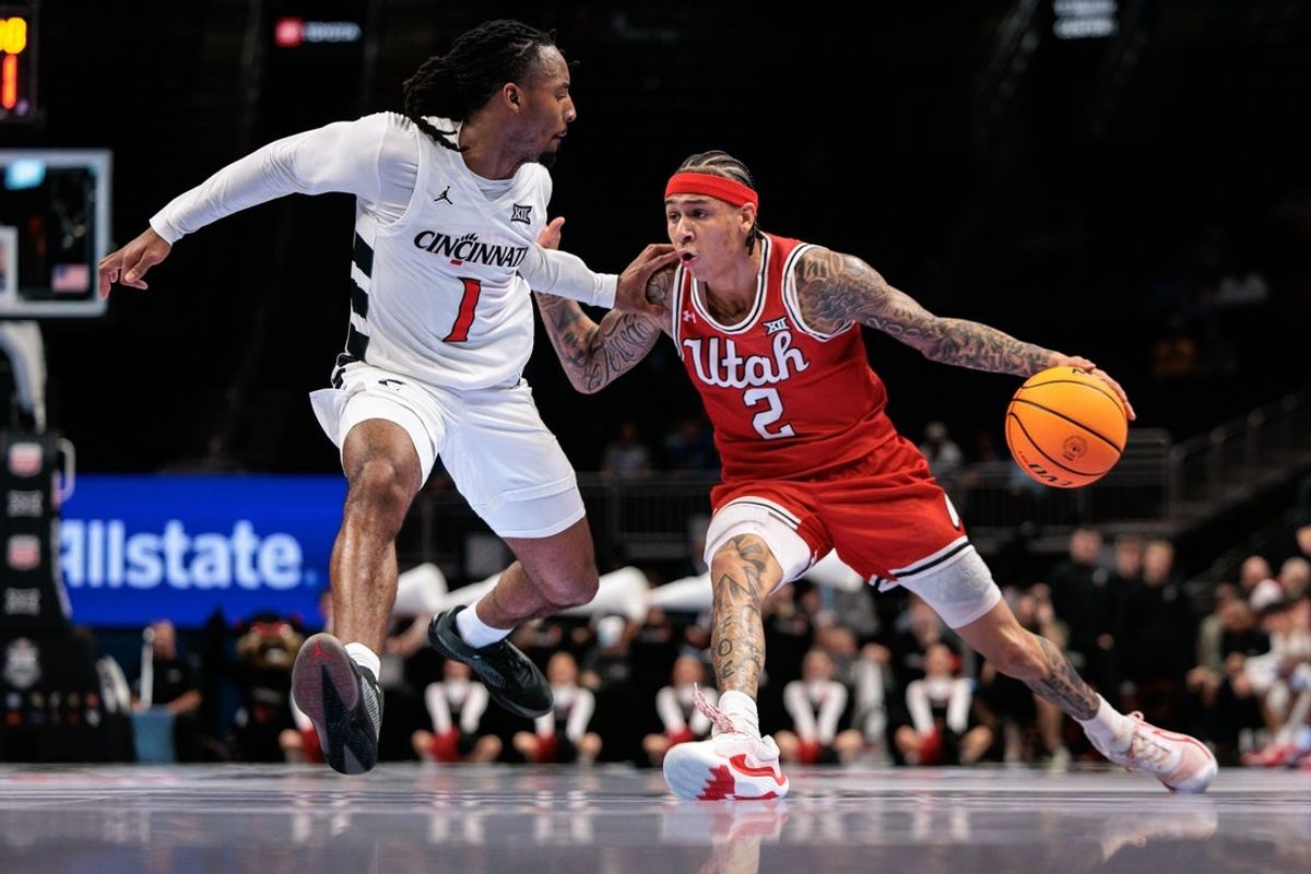 Mar 10, 2026; Kansas City, MO, USA; Utah Utes guard Terrence Brown (2) drives around Cincinnati Bearcats guard Day Day Thomas (1) during the second half at T-Mobile Center. Mandatory Credit: William Purnell-Imagn Images