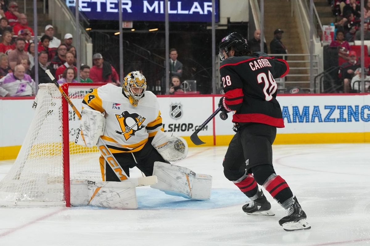 Mar 10, 2026; Raleigh, North Carolina, USA;  Pittsburgh Penguins goaltender Stuart Skinner (74) and Carolina Hurricanes left wing William Carrier (28) watch the shot during the first period at Lenovo Center. Mandatory Credit: James Guillory-Imagn Images