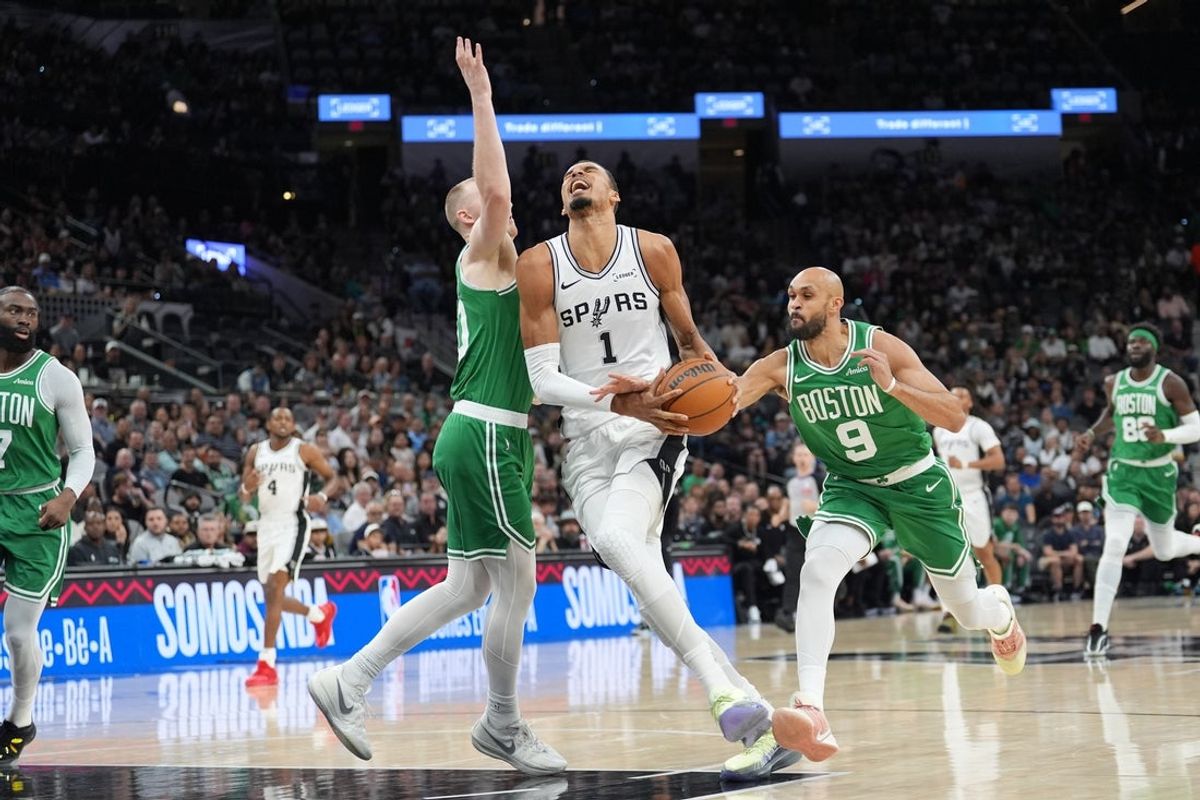 Mar 10, 2026; San Antonio, Texas, USA; San Antonio Spurs forward Victor Wembanyama (1) drives to the basket against Boston Celtics forward Sam Hauser (30) and guard Derrick White (9) in the first half at Frost Bank Center. Mandatory Credit: Daniel Dunn-Imagn Images