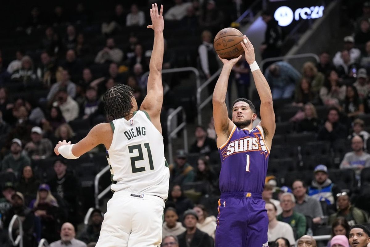 Mar 10, 2026; Milwaukee, Wisconsin, USA;  Phoenix Suns guard Devin Booker (1) shoots against Milwaukee Bucks forward Ousmane Dieng (21) during the third quarter at Fiserv Forum. Mandatory Credit: Jeff Hanisch-Imagn Images