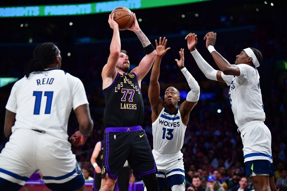 Mar 10, 2026; Los Angeles, California, USA; Los Angeles Lakers guard Luka Doncic (77) shoots against the defense of Minnesota Timberwolves center Naz Reid (11) guard Ayo Dosunmu (13) and forward Jaden McDaniels (3) during the first half at Crypto.com Arena. Mandatory Credit: Gary A. Vasquez-Imagn Images