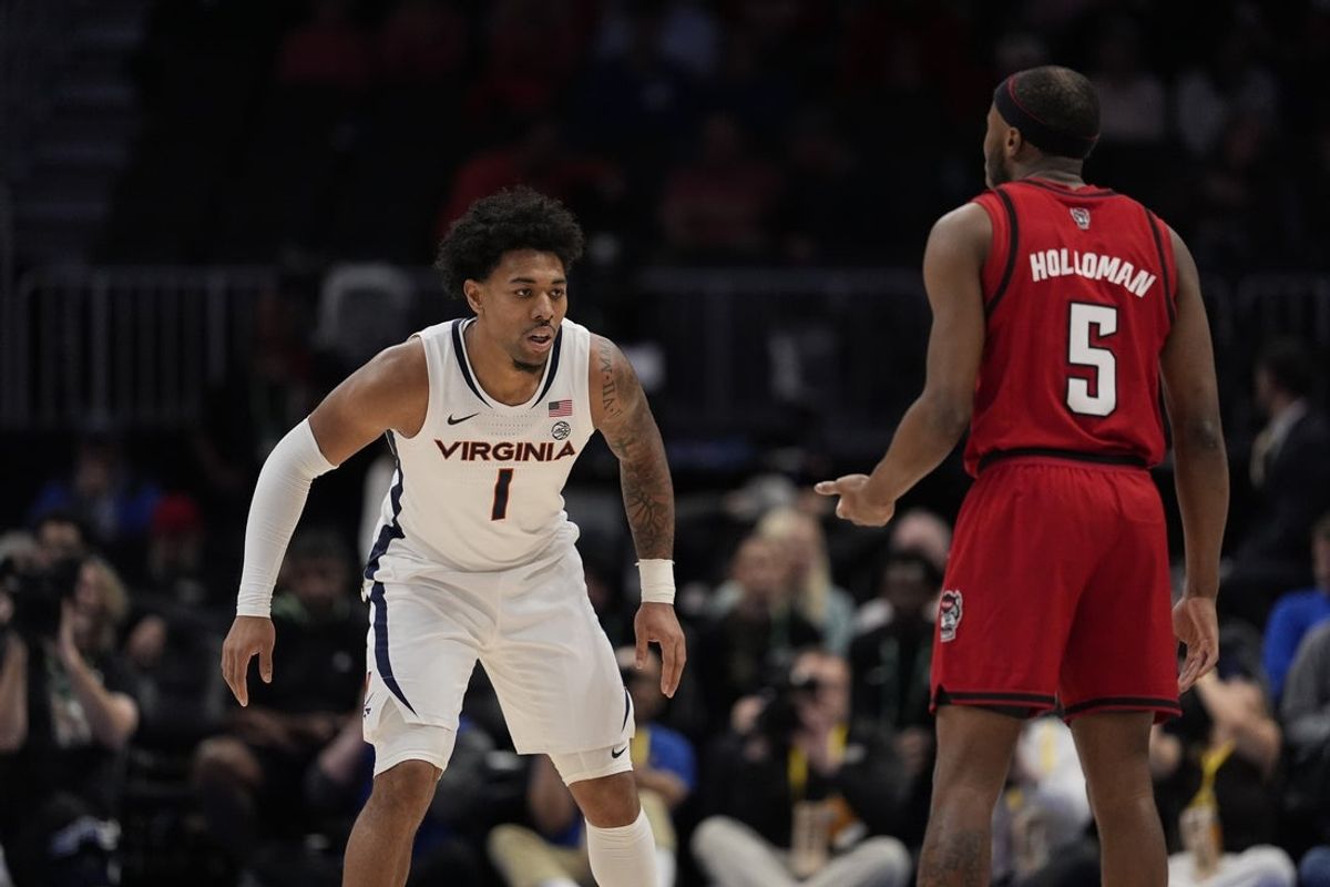 Mar 12, 2026; Charlotte, NC, USA; Virginia Cavaliers guard Malik Thomas (1) on defense against NC State Wolfpack guard Tre Holloman (5) during the first half at Spectrum Center. Mandatory Credit: Jim Dedmon-Imagn Images