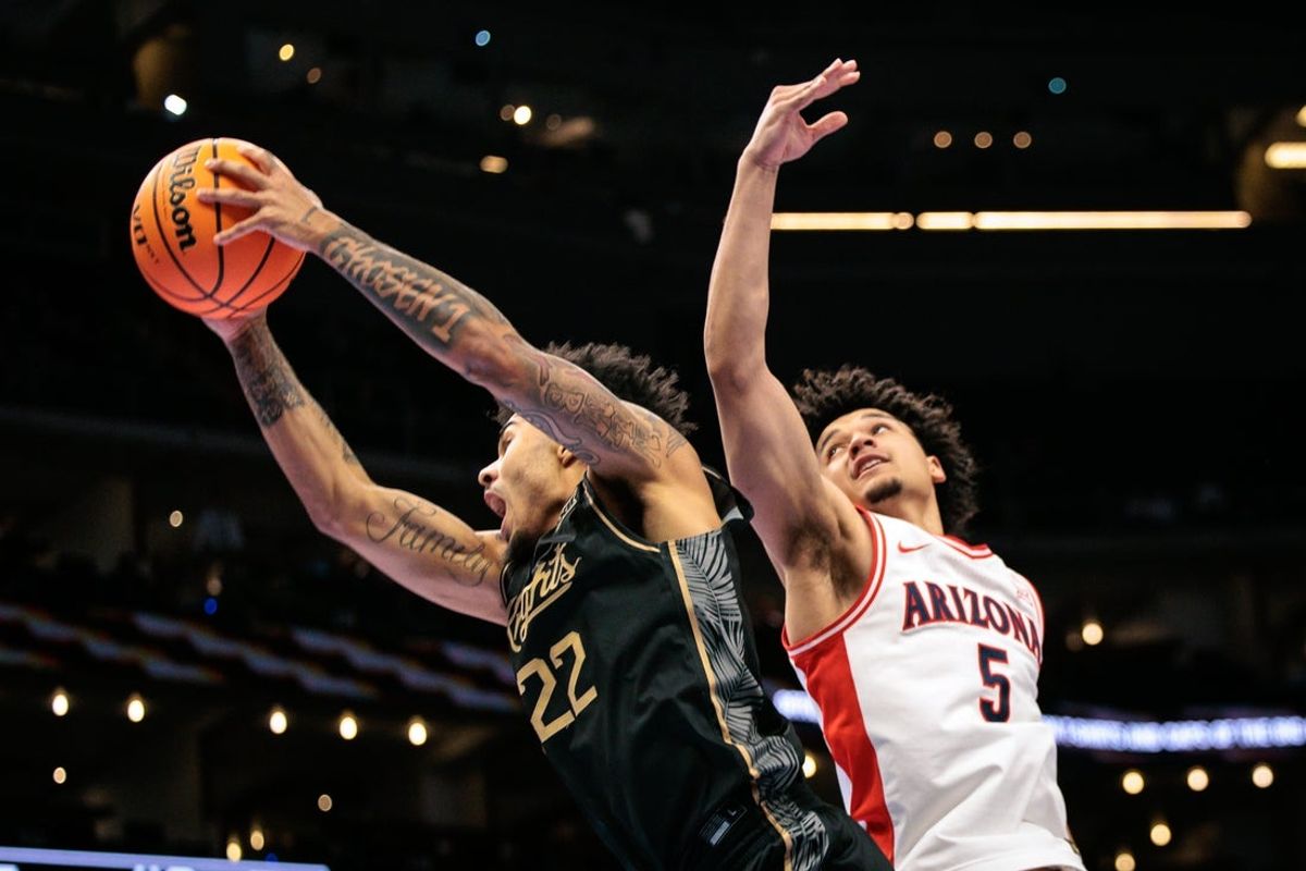 Mar 12, 2026; Kansas City, MO, USA; Arizona Wildcats guard Brayden Burries (5) and UCF Knights guard Chris Johnson (22) go after a rebound during the second half at T-Mobile Center. Mandatory Credit: William Purnell-Imagn Images