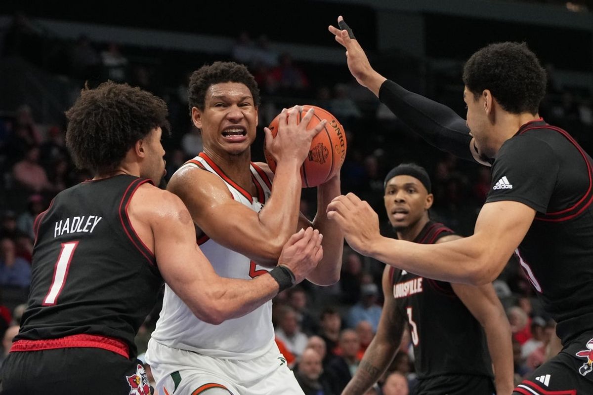 Mar 12, 2026; Charlotte, NC, USA; Miami (FL) Hurricanes forward Malik Reneau (5) with the ball as Louisville Cardinals guard J'vonne Hadley (1) and forward Sananda Fru (13) defend in the second half at Spectrum Center. Mandatory Credit: Bob Donnan-Imagn Images