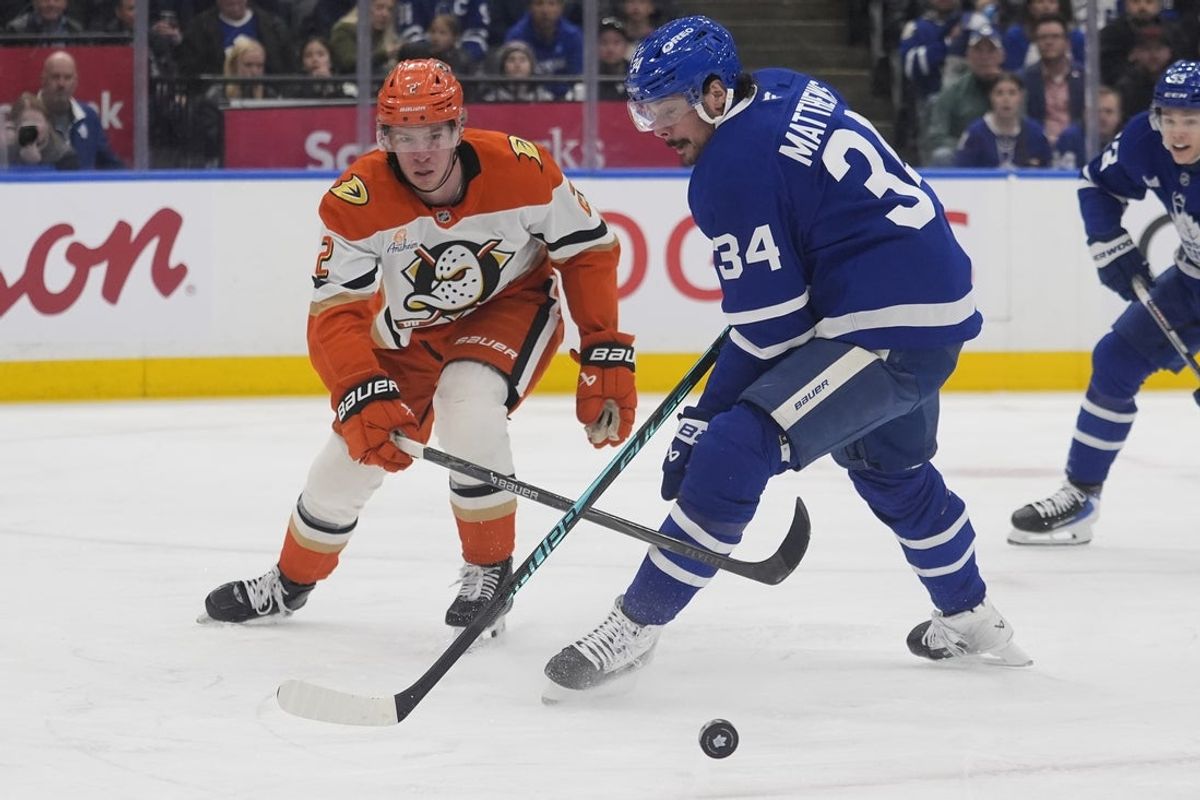 Mar 12, 2026; Toronto, Ontario, CAN; Anaheim Ducks defenseman Jackson LaCombe (2) knocks the puck away from Toronto Maple Leafs forward Auston Matthews (34) during the first period at Scotiabank Arena. Mandatory Credit: John E. Sokolowski-Imagn Images