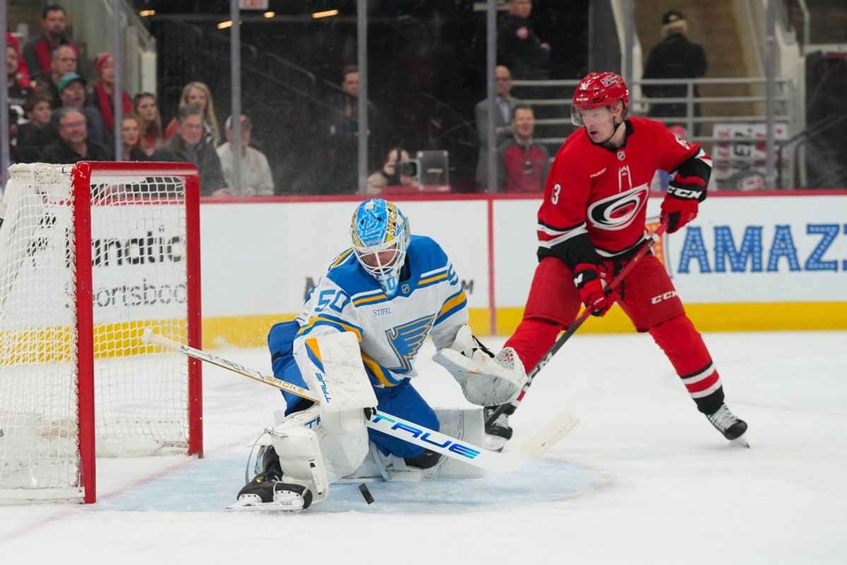 Mar 12, 2026; Raleigh, North Carolina, USA;  St. Louis Blues goaltender Jordan Binnington (50) stops the shot in front of Carolina Hurricanes right wing Jackson Blake (53) during the first period at Lenovo Center. Mandatory Credit: James Guillory-Imagn Images