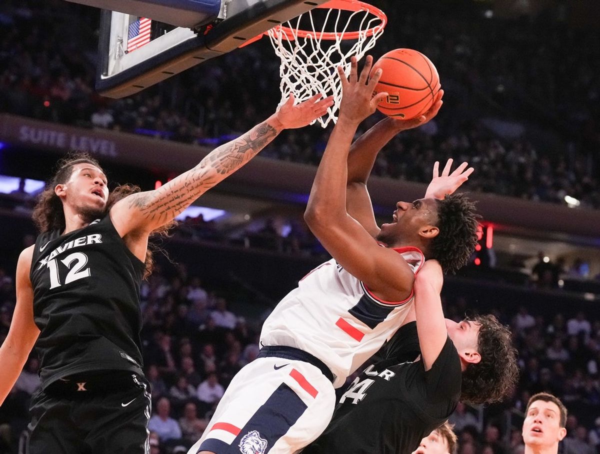 Mar 12, 2026; New York, NY, USA;  UConn Huskies forward Tarris Reed Jr. (5) shoots past Xavier Musketeers forward Tre Carroll (12) and Xavier Musketeers forward Jovan Milicevic (24) during the first half at Madison Square Garden. Mandatory Credit: Robert Deutsch-Imagn Images