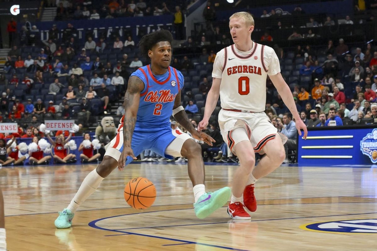 Mar 12, 2026; Nashville, TN, USA;  Mississippi Rebels guard AJ Storr (2) drives to the basket past Georgia Bulldogs guard Blue Cain (0) during the second half at Bridgestone Arena. Mandatory Credit: Steve Roberts-Imagn Images