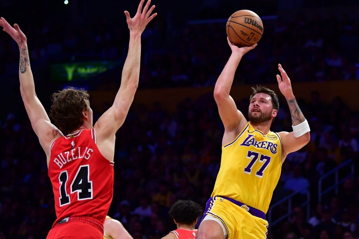 Mar 12, 2026; Los Angeles, California, USA; Los Angeles Lakers guard Luka Doncic (77) shoots against Chicago Bulls forward Matas Buzelis (14) during the first half at Crypto.com Arena. Mandatory Credit: Gary A. Vasquez-Imagn Images