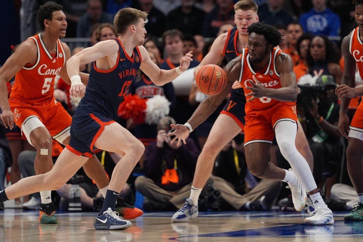 Mar 13, 2026; Charlotte, NC, USA; Virginia Cavaliers center Johann Grünloh (17) and Miami Hurricanes center Ernest Udeh Jr. (8) fights for possession during the first half at Spectrum Center. Mandatory Credit: Jim Dedmon-Imagn Images