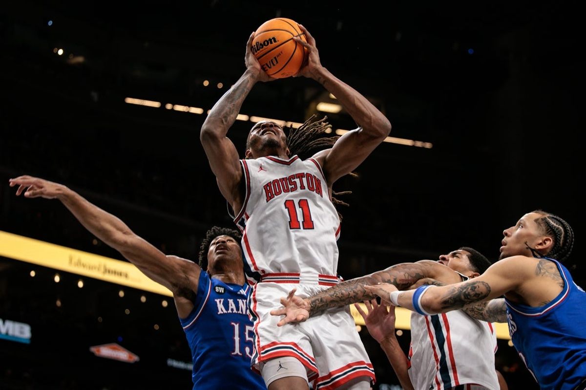 Mar 13, 2026; Kansas City, MO, USA; Houston Cougars forward Joseph Tugler (11) shoots the ball in front of Kansas Jayhawks forward Bryson Tiller (15) during the first half at T-Mobile Center. Mandatory Credit: William Purnell-Imagn Images