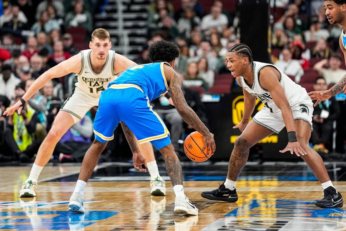 Michigan State center Carson Cooper (15) and guard Jeremy Fears Jr. (1) defend UCLA guard Donovan Dent (2) during the second half of Big Ten tournament quarterfinal at United Center in Chicago on Friday, March 13, 2026.