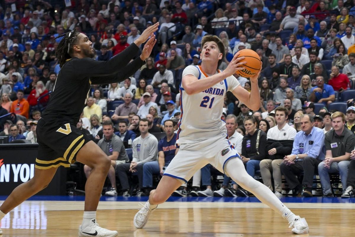 Mar 14, 2026; Nashville, TN, USA;  Florida Gators forward Alex Condon (21) head fakes Vanderbilt Commodores forward Devin McGlockton (99) during the first half at Bridgestone Arena. Mandatory Credit: Steve Roberts-Imagn Images