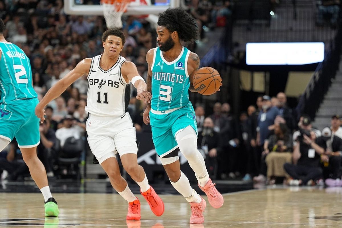 Mar 14, 2026; San Antonio, Texas, USA;  Charlotte Hornets guard Coby White (3) dribbles past San Antonio Spurs forward Carter Bryant (11) in the first half at Frost Bank Center. Mandatory Credit: Daniel Dunn-Imagn Images