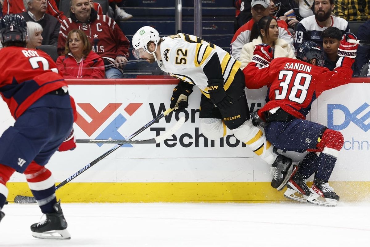 Mar 9, 2026; Washington, District of Columbia, USA; Washington Capitals defenseman Rasmus Sandin (38) checks Boston Bruins center Sean Kuraly (52) during the second period at Capital One Arena. Mandatory Credit: Geoff Burke-Imagn Images