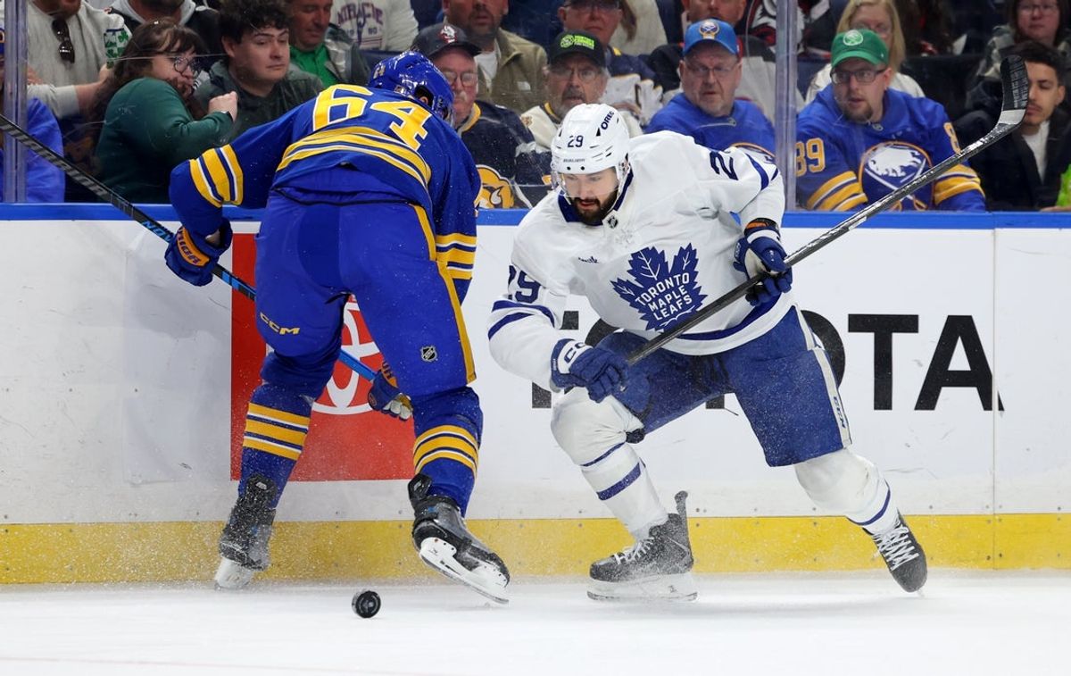 Mar 14, 2026; Buffalo, New York, USA;  Buffalo Sabres defenseman Logan Stanley (64) misses his check as Toronto Maple Leafs center Bo Groulx (29) looks to control the puck during the first period at KeyBank Center. Mandatory Credit: Timothy T. Ludwig-Imagn Images