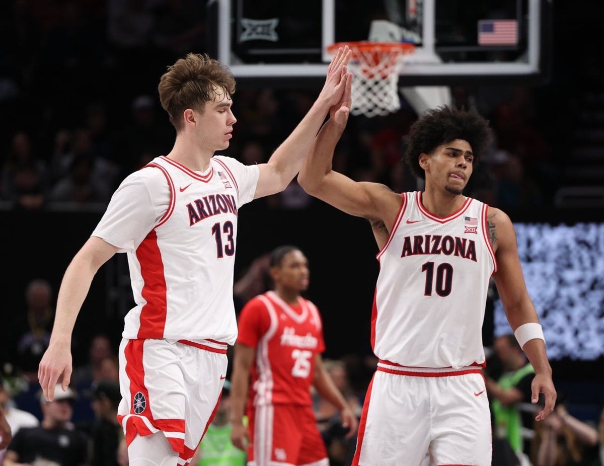 Mar 14, 2026; Kansas City, MO, USA; Arizona Wildcats center Motiejus Krivas (13) and forward Koa Peat (10) high-five during the second half against the Houston Cougars during the men's Big 12 Conference Tournament Championship at T-Mobile Center. Mandatory Credit: William Purnell-Imagn Images