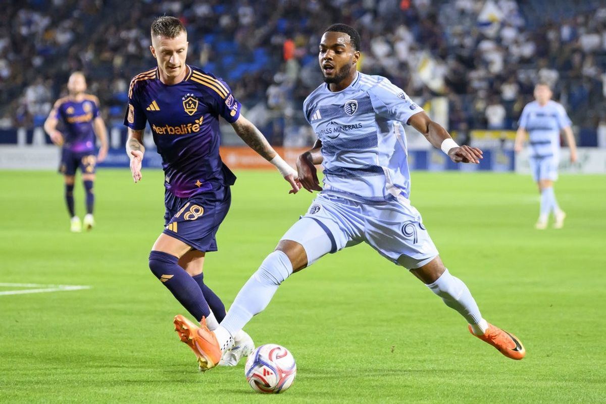 Mar 14, 2026; Carson, California, USA; Sporting Kansas City defender Jayden Reid (99) handles the ball while LA Galaxy midfielder Marco Reus (18) defends during the first half at Dignity Health Sports Park. Mandatory Credit: Kelvin Kuo-Imagn Images