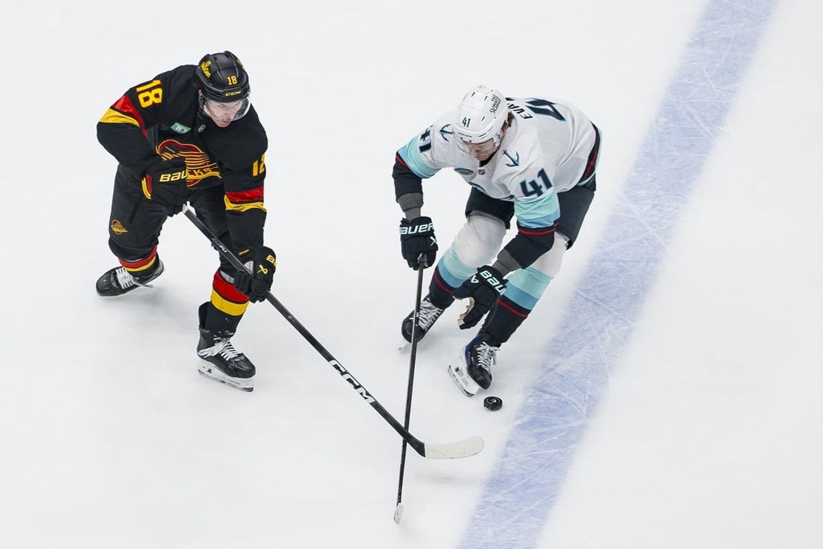 Mar 14, 2026; Vancouver, British Columbia, CAN; Seattle Kraken defenseman Ryker Evans (41) stick checks Vancouver Canucks forward Drew O'Connor (18) in the first period at Rogers Arena. Mandatory Credit: Bob Frid-Imagn Images