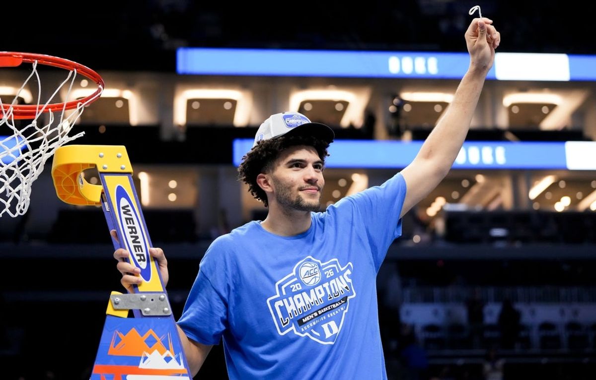 Mar 14, 2026; Charlotte, NC, USA; Duke Blue Devils forward Cameron Boozer (12) cuts down the net after defeating the Virginia Cavaliers in the men's ACC Conference Tournament Championship at Spectrum Center. Mandatory Credit: Bob Donnan-Imagn Images