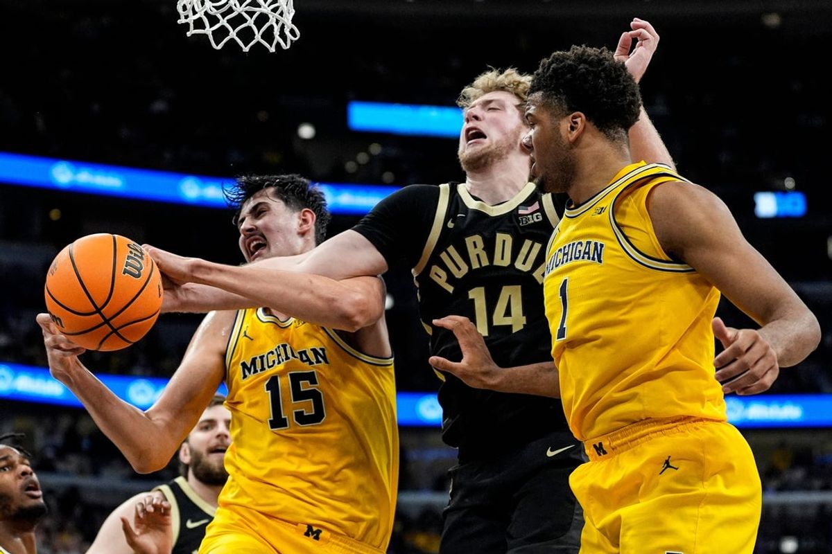Michigan center Aday Mara (15) and Purdue guard Jack Benter (14) battle for a rebound during the first half of Big Ten Tournament final at United Center in Chicago on Sunday, March 15, 2026.