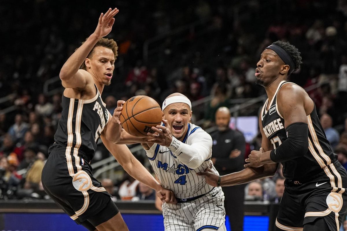 Mar 16, 2026; Atlanta, Georgia, USA; Orlando Magic guard Jalen Suggs (4) tries to go between Atlanta Hawks guard Dyson Daniels (5) and forward Onyeka Okongwu (17) during the first half at State Farm Arena. Mandatory Credit: Dale Zanine-Imagn Images