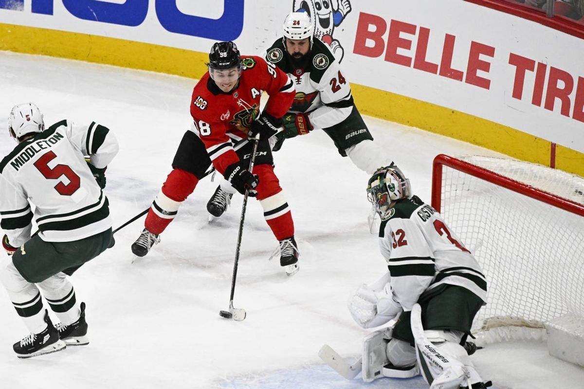 Mar 17, 2026; Chicago, Illinois, USA;  Chicago Blackhawks center Connor Bedard (98) moves the puck against Minnesota Wild defenseman Zach Bogosian (24) and goaltender Filip Gustavsson (32) during the second period at United Center. Mandatory Credit: Matt Marton-Imagn Images