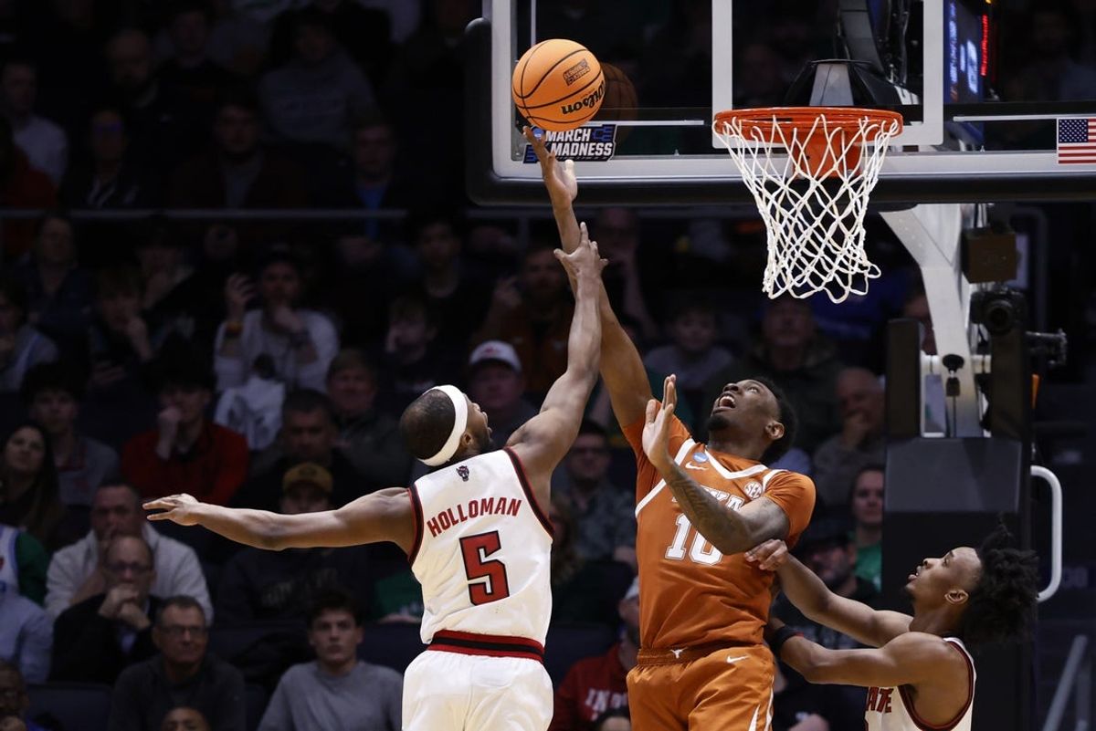 Mar 17, 2026; Dayton, OH, USA; Texas Longhorns forward Nic Codie (10) shoots the ball defended by NC State Wolfpack guard Tre Holloman (5) in the first half during a first four game of the men's 2026 NCAA Tournament at University of Dayton Arena. Mandatory Credit: Rick Osentoski-Imagn Images